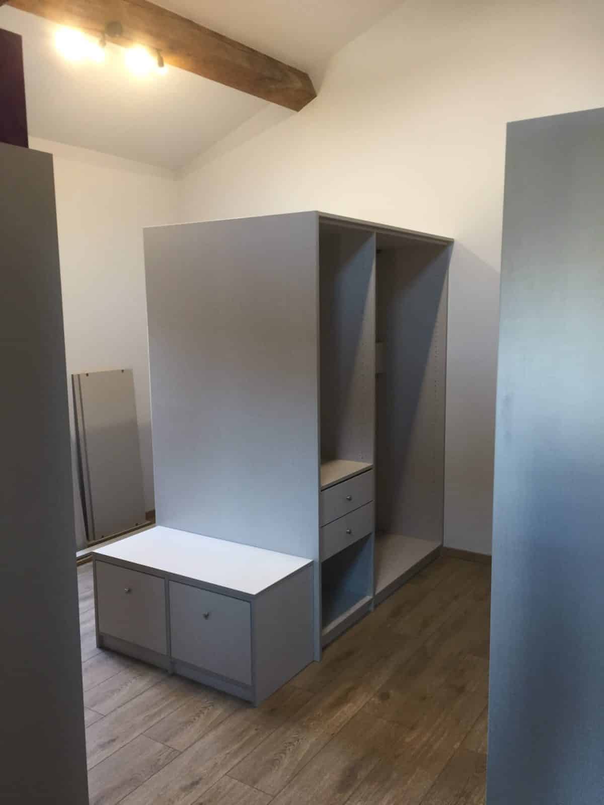 Dressing sur mesure gris et blanc pour chambre moderne Dressing gris et blanc avec tiroirs sur parquet clair dans une chambre mansardée.